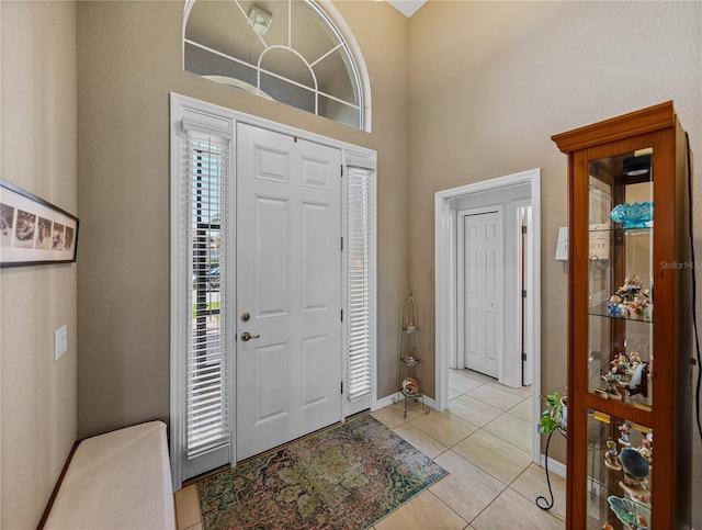 tiled foyer entrance featuring a high ceiling