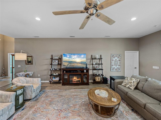 living room featuring wood-type flooring and ceiling fan