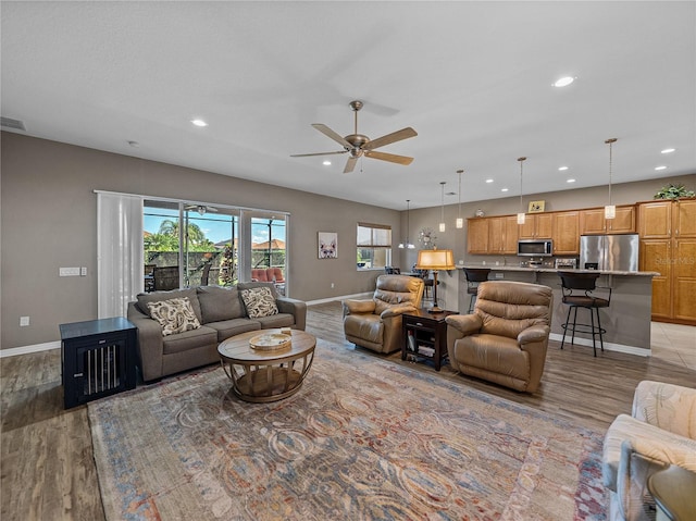 living room with ceiling fan and light wood-type flooring