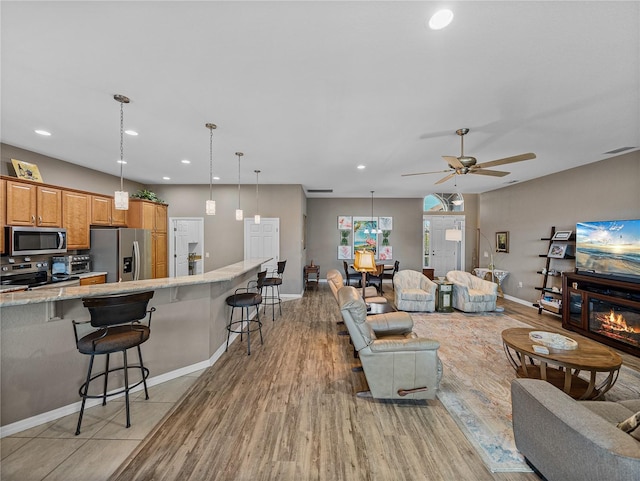 living room featuring light hardwood / wood-style flooring and ceiling fan