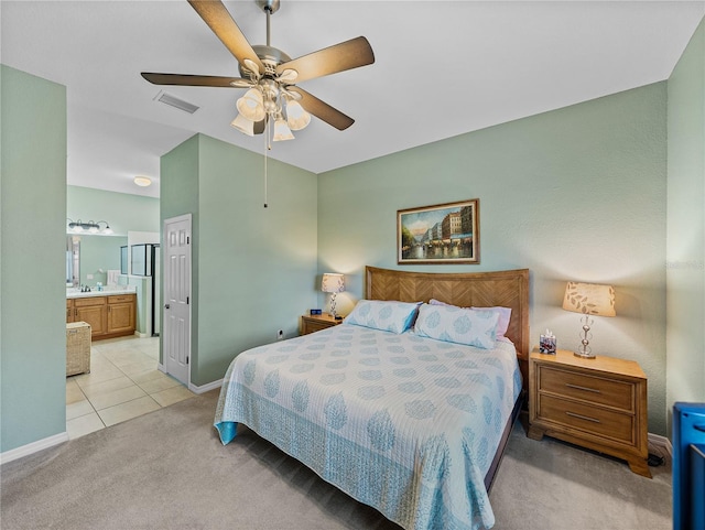 carpeted bedroom with ensuite bath and ceiling fan