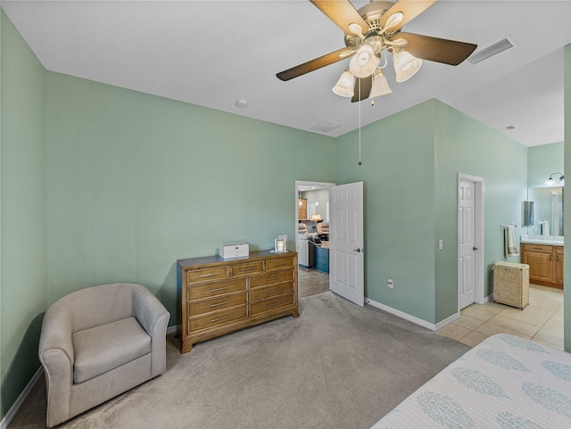 bedroom featuring ensuite bathroom, light carpet, and ceiling fan