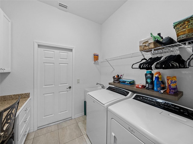 laundry area featuring separate washer and dryer, light tile patterned floors, sink, and cabinets