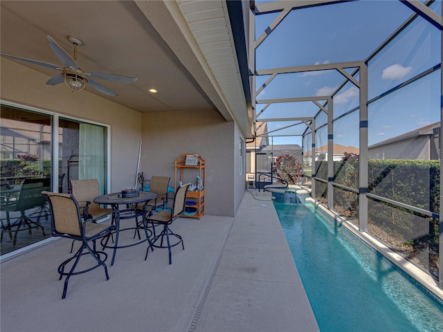 view of swimming pool with an in ground hot tub, a lanai, ceiling fan, and a patio area