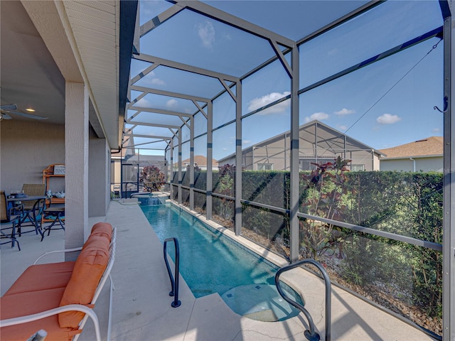 view of pool with a patio area, an in ground hot tub, and glass enclosure