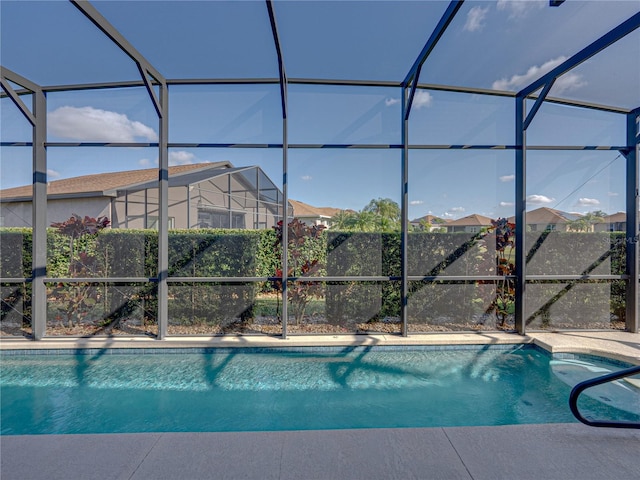 view of swimming pool featuring a lanai