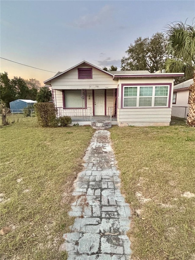 bungalow-style home featuring a yard and covered porch