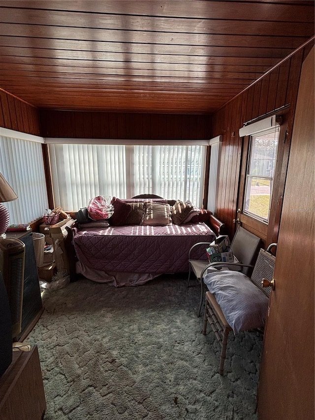 bedroom featuring carpet, wooden ceiling, and wooden walls