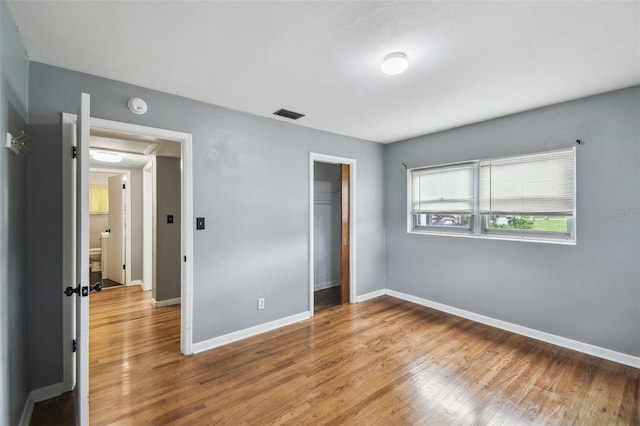 unfurnished bedroom featuring light hardwood / wood-style floors and a closet