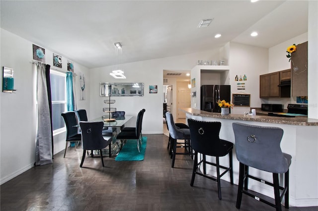 dining area with lofted ceiling and dark parquet floors