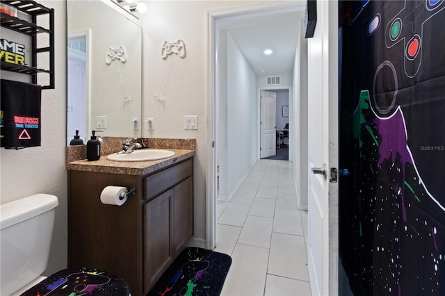 bathroom featuring vanity, tile patterned floors, and toilet