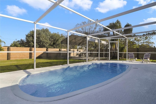 view of swimming pool with a yard, a patio area, and glass enclosure