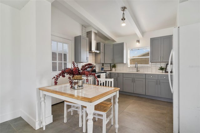 kitchen with white fridge, sink, gray cabinetry, and decorative backsplash