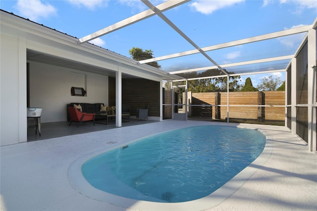 view of swimming pool featuring outdoor lounge area, a patio, and glass enclosure