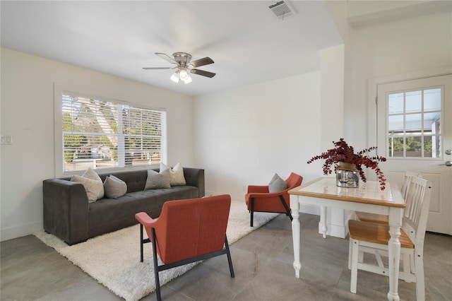 living room with ceiling fan and concrete flooring