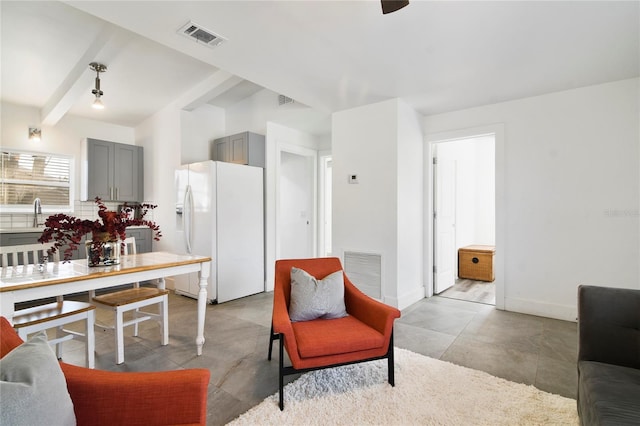 living room with beam ceiling and sink