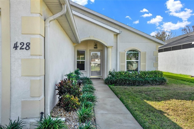 entrance to property with a lawn