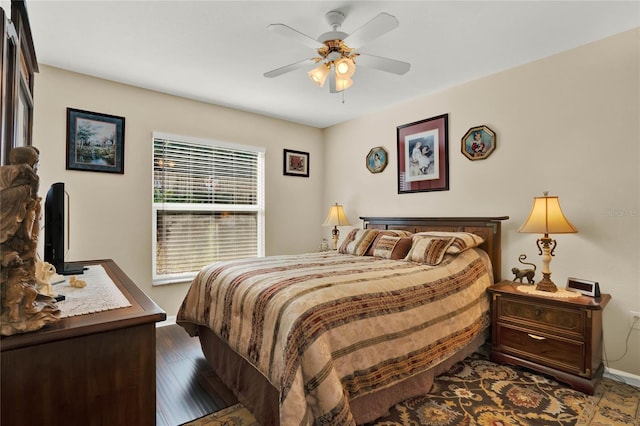 bedroom with ceiling fan and dark hardwood / wood-style flooring