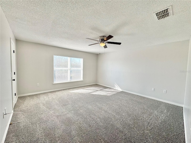 spare room with a textured ceiling, carpet floors, and ceiling fan