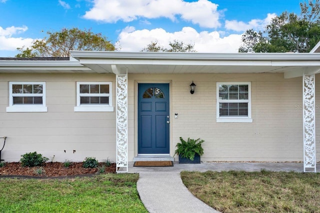 doorway to property with a lawn