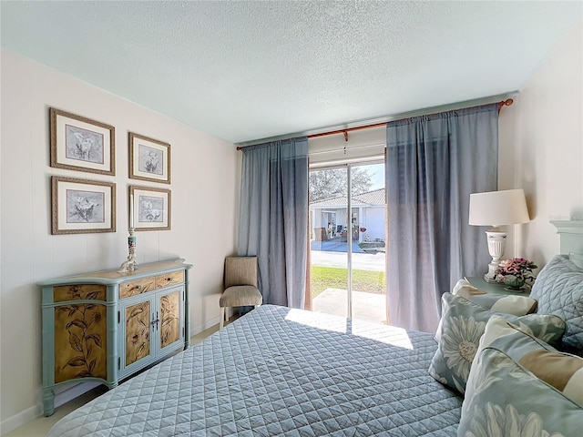 bedroom featuring access to exterior and a textured ceiling