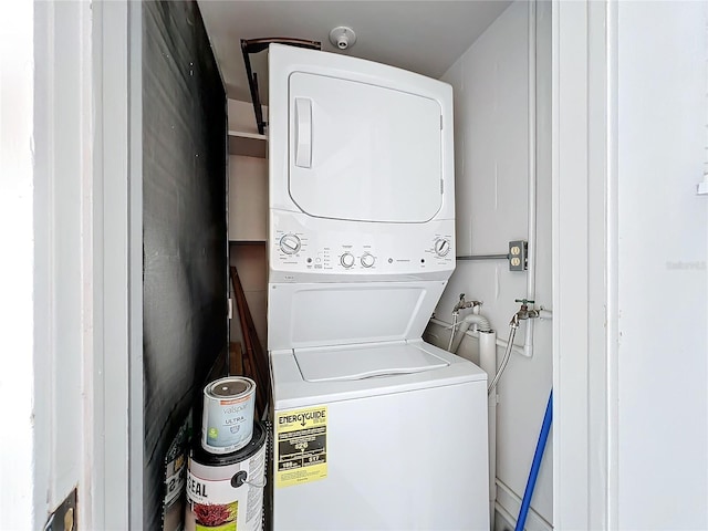 clothes washing area with stacked washer / dryer