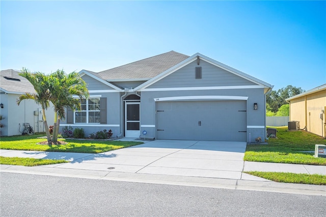 view of front facade with a garage, central AC, and a front yard