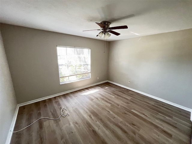 empty room with dark wood-type flooring and ceiling fan