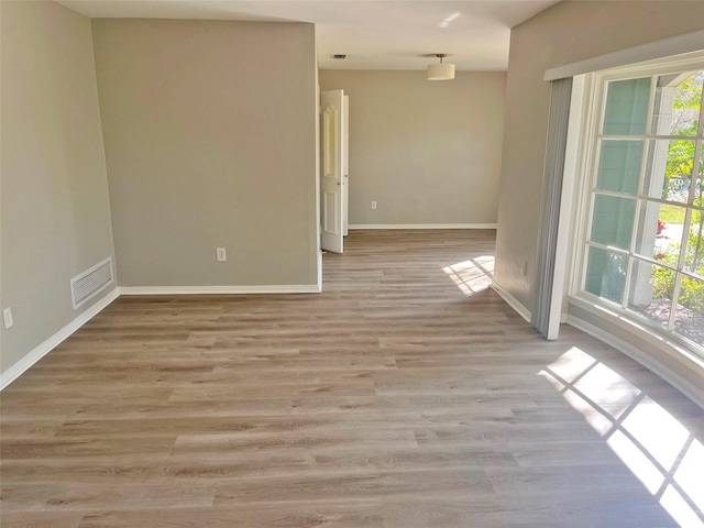 unfurnished room with plenty of natural light and light hardwood / wood-style flooring