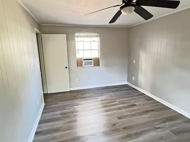 spare room featuring cooling unit, ornamental molding, ceiling fan, wooden walls, and dark hardwood / wood-style floors