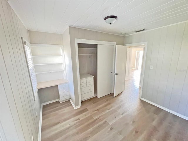 unfurnished bedroom with light wood-type flooring and a closet