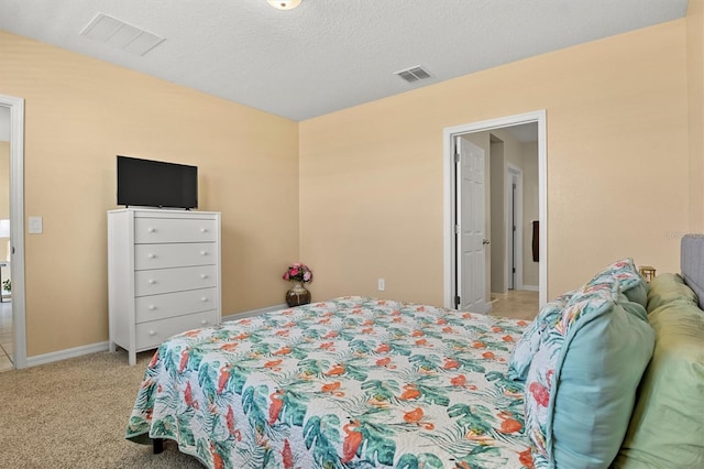 bedroom featuring light colored carpet and a textured ceiling