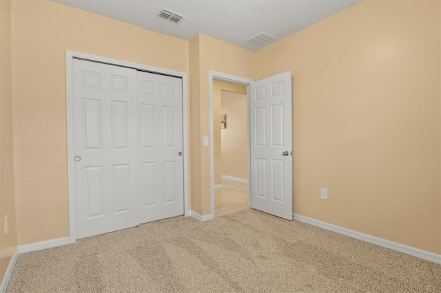 unfurnished bedroom with a closet, carpet, and a textured ceiling