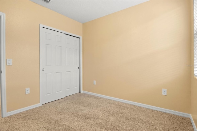 unfurnished bedroom featuring carpet flooring and a closet