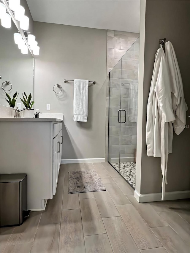 bathroom with vanity, a shower with shower door, and a chandelier