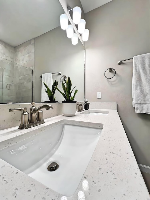 bathroom with vanity, a notable chandelier, and a shower with door