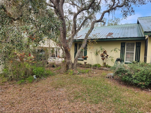 view of front of home featuring stucco siding and metal roof