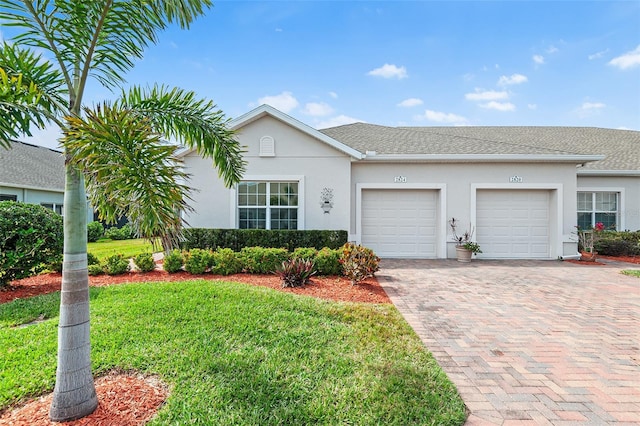 ranch-style home featuring a garage and a front lawn