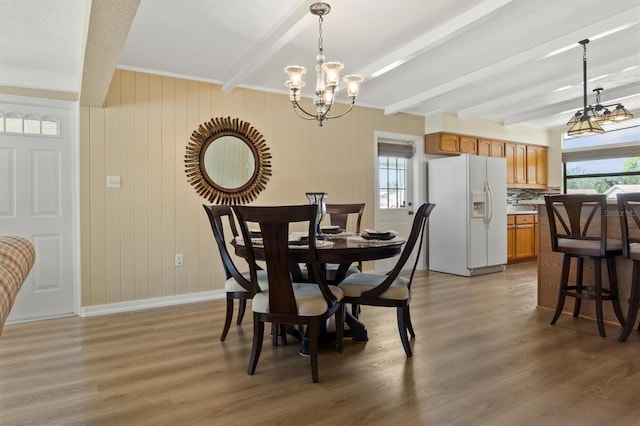 dining room with a notable chandelier, beam ceiling, and dark hardwood / wood-style floors