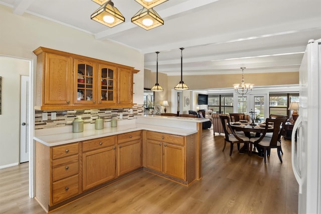 kitchen featuring pendant lighting, decorative backsplash, white refrigerator, kitchen peninsula, and beam ceiling