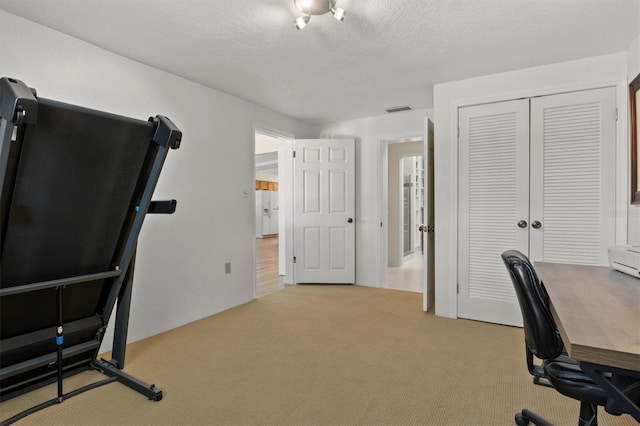 carpeted office space with a textured ceiling