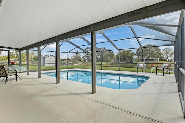 view of swimming pool with a lawn, glass enclosure, and a patio area