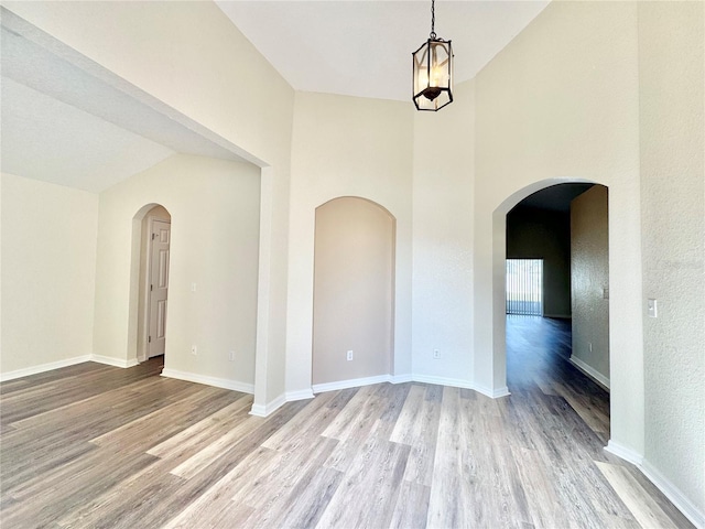 unfurnished room with high vaulted ceiling and light hardwood / wood-style floors