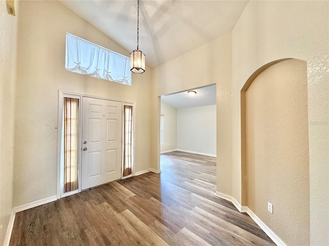 entrance foyer featuring wood-type flooring and high vaulted ceiling