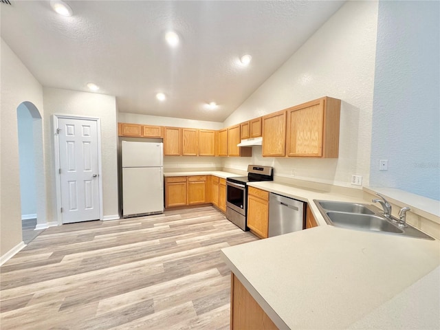 kitchen with sink, light hardwood / wood-style flooring, stainless steel appliances, vaulted ceiling, and kitchen peninsula