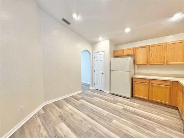 kitchen with light hardwood / wood-style flooring and white refrigerator