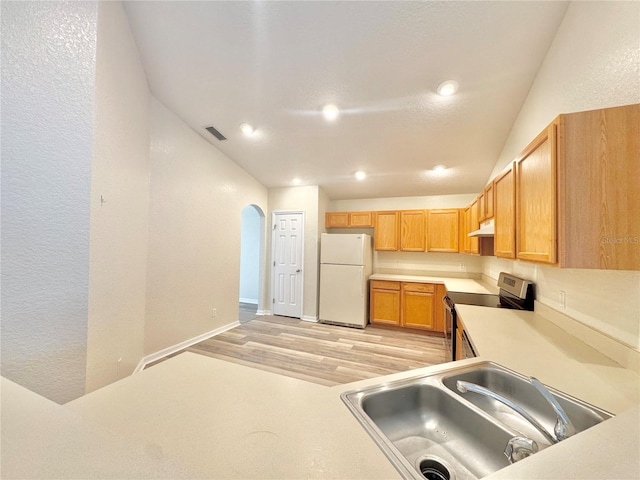 kitchen with white refrigerator, vaulted ceiling, sink, and electric stove