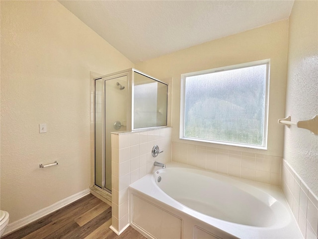 bathroom featuring shower with separate bathtub, wood-type flooring, a textured ceiling, and toilet