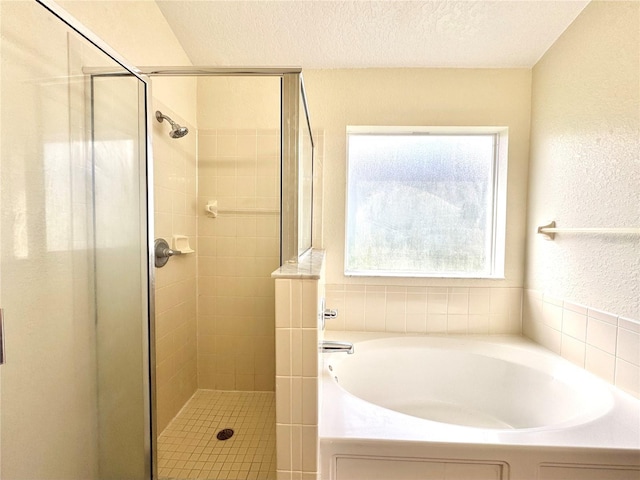 bathroom with plus walk in shower and a textured ceiling