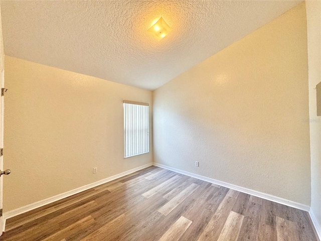 empty room with wood-type flooring and a textured ceiling